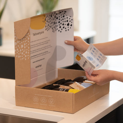 Someone opening a plastic-free cleaning starter kit