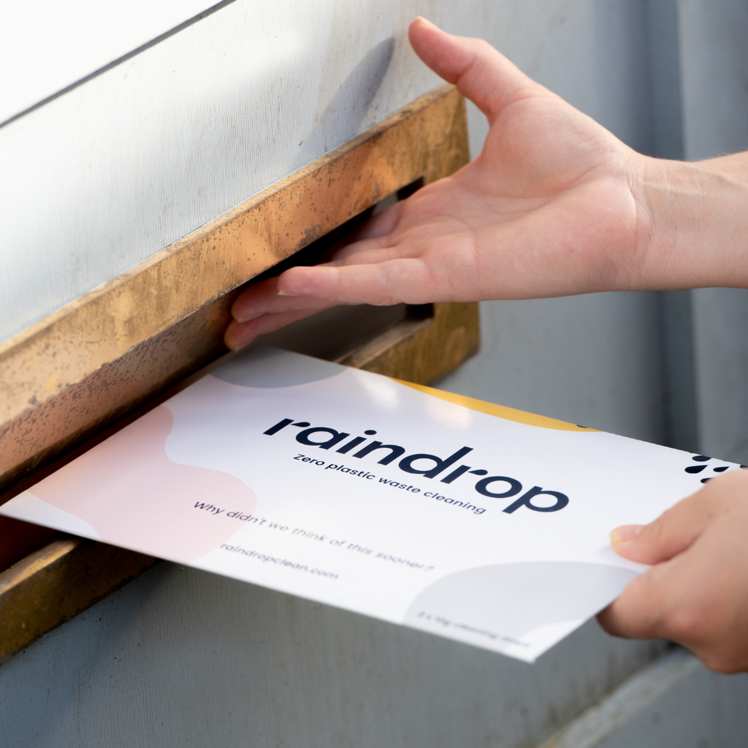 Someone delivering a pack of plastic-free kitchen cleaning refills through a gold postbox